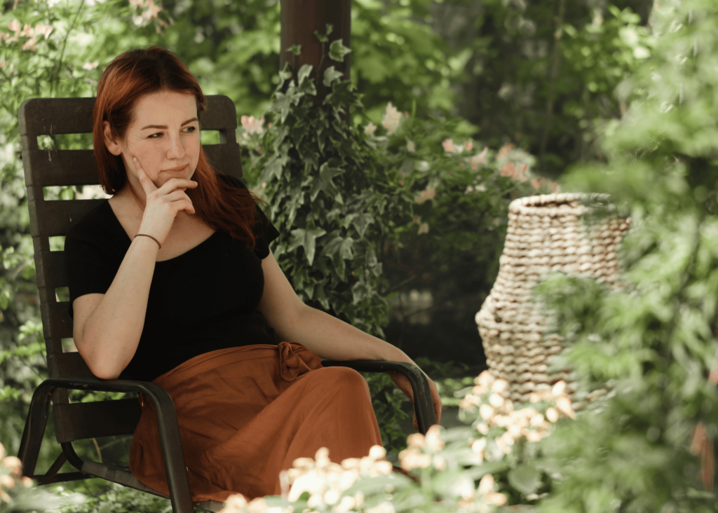 a woman taking a moment to enjoy and reflect in her garden