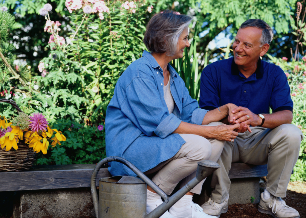 a couple taking a break from light gardening chores, picking flowers and watering, to enjoy each other and the garden